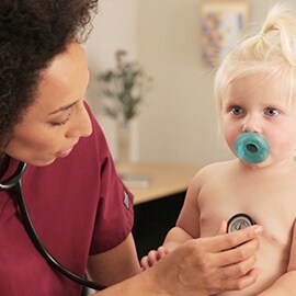 Infirmière en pédiatrie écoutant la cavité thoracique d’un enfant à l’aide d’un stéthoscope 3M Littmann Classic III. 