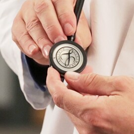 Plan rapproché d’un médecin tenant le pavillon d’un stéthoscope 3M Littmann doté du joint Littmann sur la membrane.