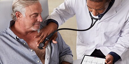 Clinicien tenant le stéthoscope numérique 3M Littmann CORE sur la poitrine d’un homme
